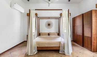 Cedar Suite bedroom with premium interiors at Punya Farms near Isha Yoga Center.