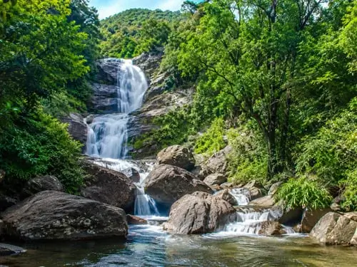 Explore the scenic Siruvani Waterfalls while enjoying a comfortable stay at Punya Farms near Coimbatore.